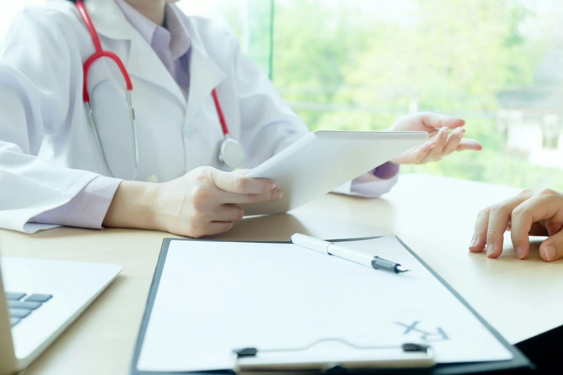 Ärztin bespricht Unterlagen mit einem Patienten in der Hausarztpraxis in Lauf